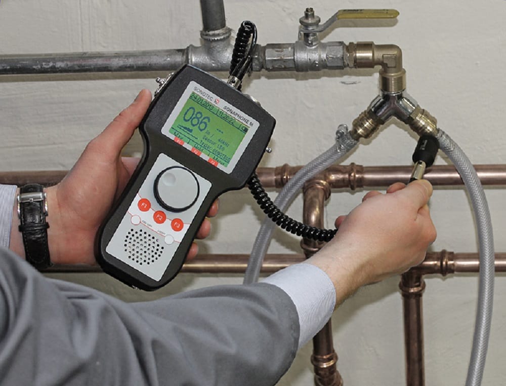 Plumber testing pipes with electronic leak detection equipment in Ontario