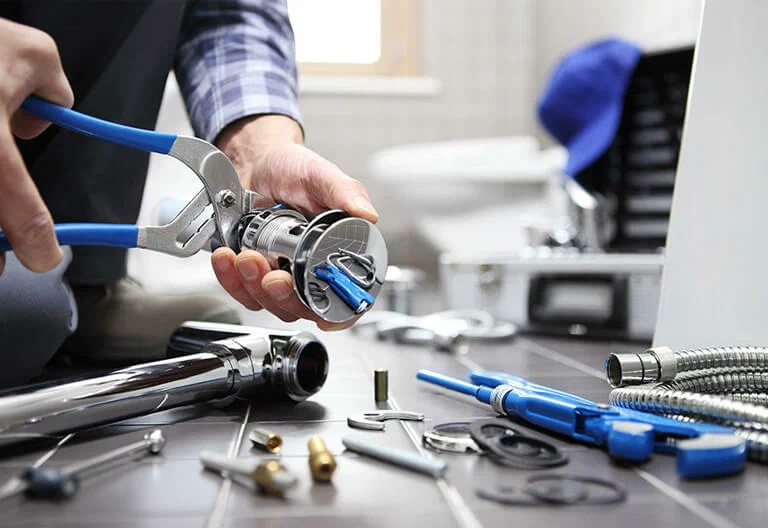 Technician repairing a plumbing fixture with professional tools in Ontario
