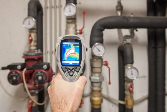 Plumber using a thermal imaging camera to inspect pipes in Ontario