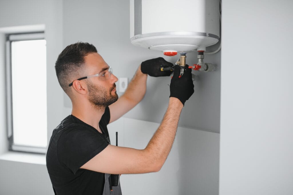 Technician performing water heater maintenance in Ontario
