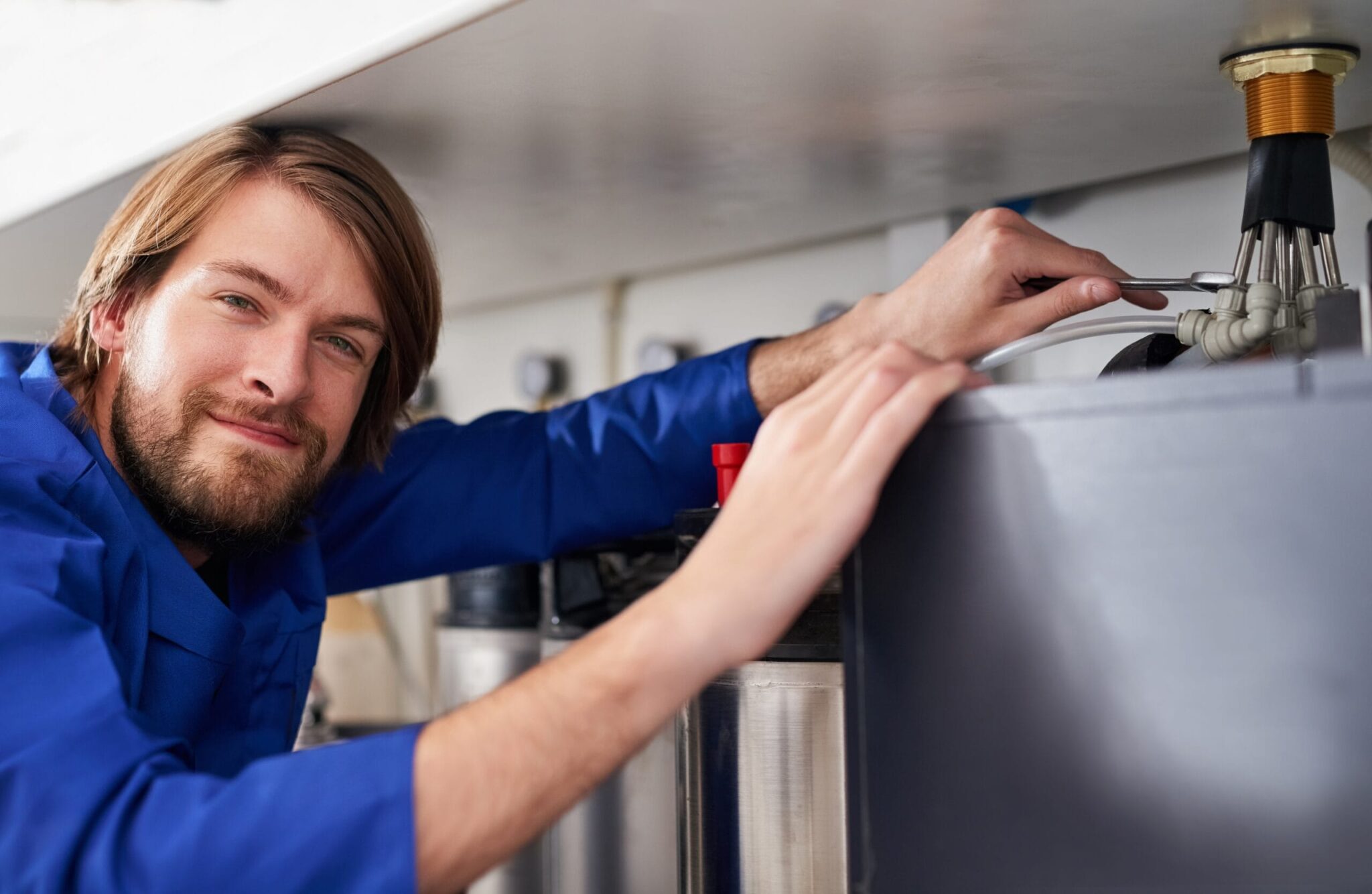 Technician servicing a residential water heater tank in Ontario