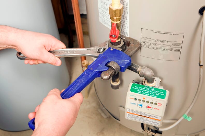 Plumber repairing a water heater valve in Ontario